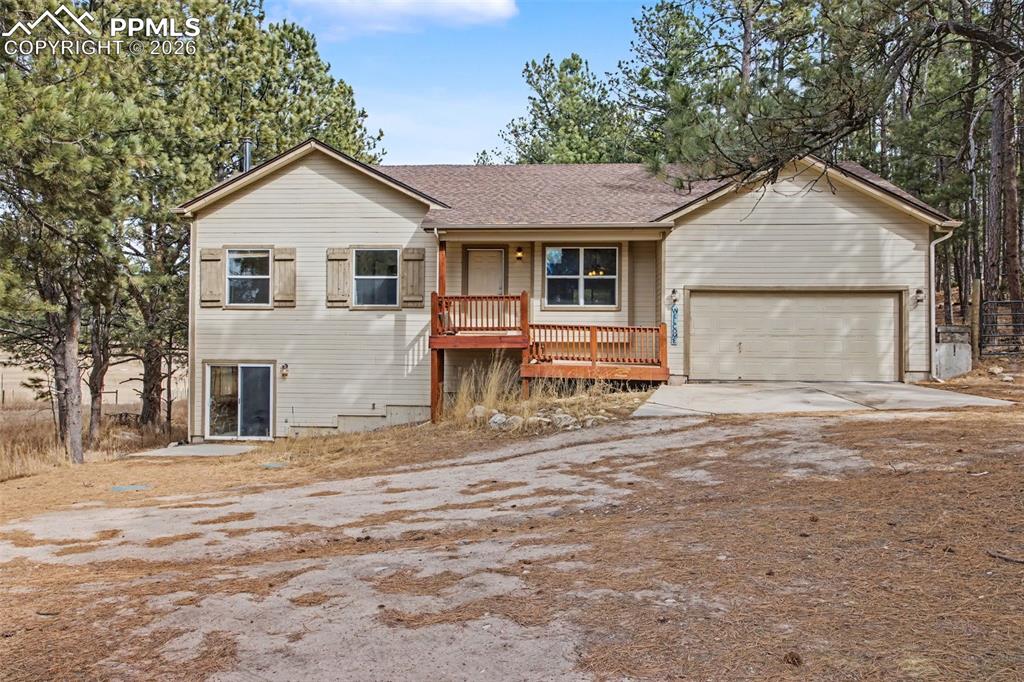 4944 Antelope Trail Elbert, CO 80106 - Photo 46 of 49 Ranch-style house featuring driveway, a porch, a shingled roof, and an attached garage