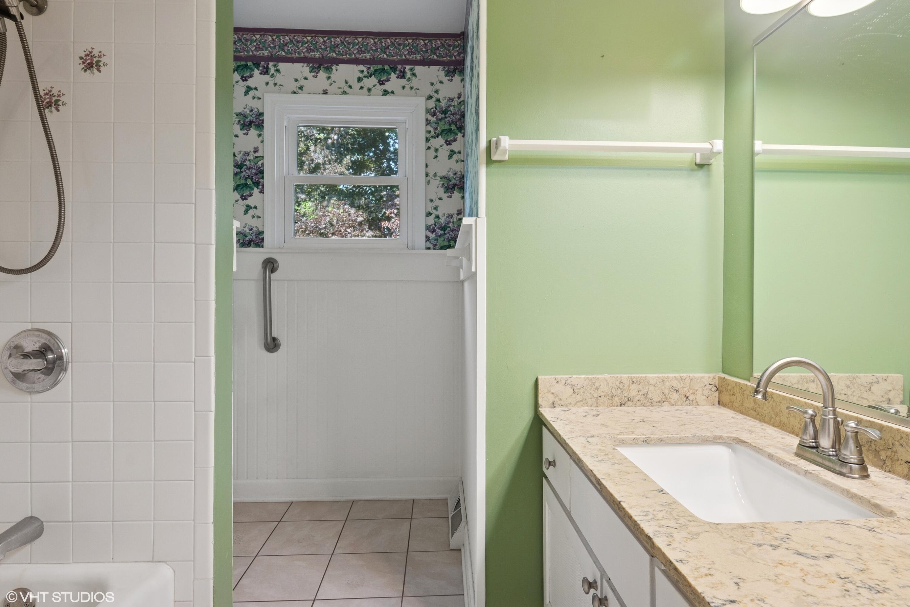 606 South 18th Street Chesterton, IN 46304 - Photo 10 of 24 a bathroom with a granite countertop shower a mirror and a sink