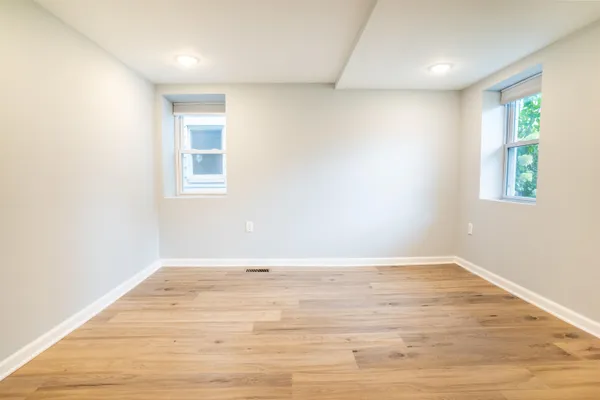 an empty room with wooden floor and window