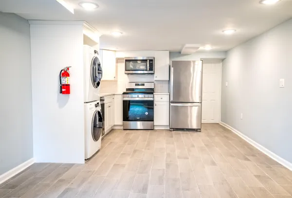 a view of a kitchen with refrigerator and wooden floor