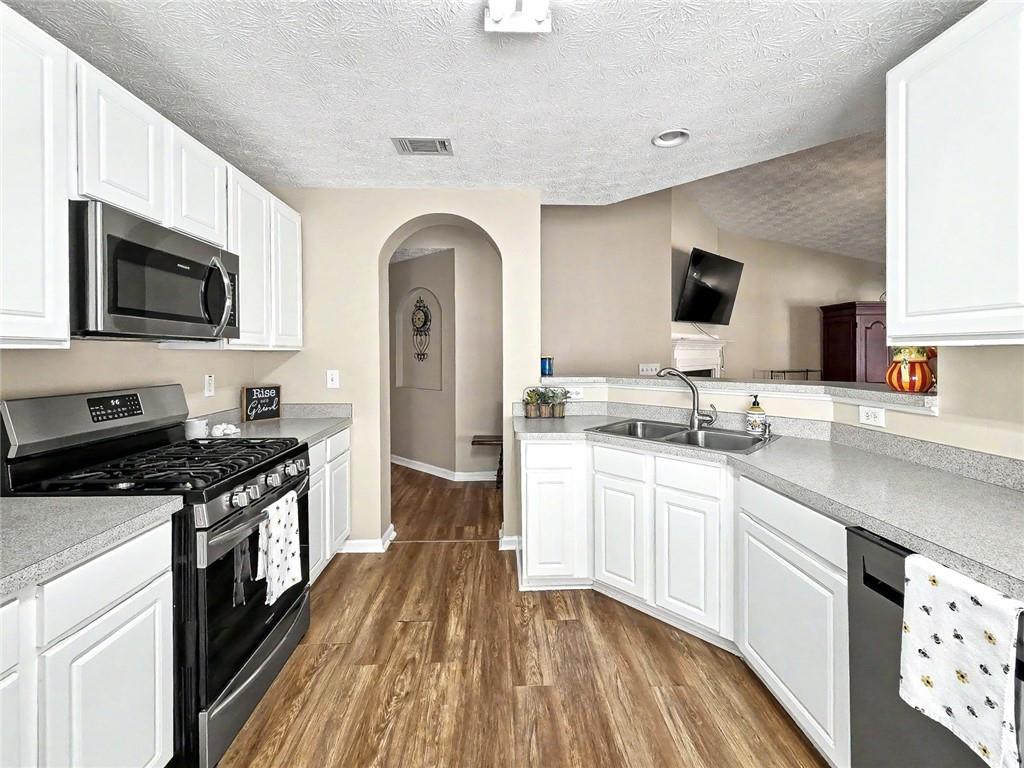 209 Diamond Valley Pass Canton, GA 30114 - Photo 11 of 27 a kitchen with stainless steel appliances granite countertop a stove top oven a sink dishwasher and a microwave oven with white cabinets