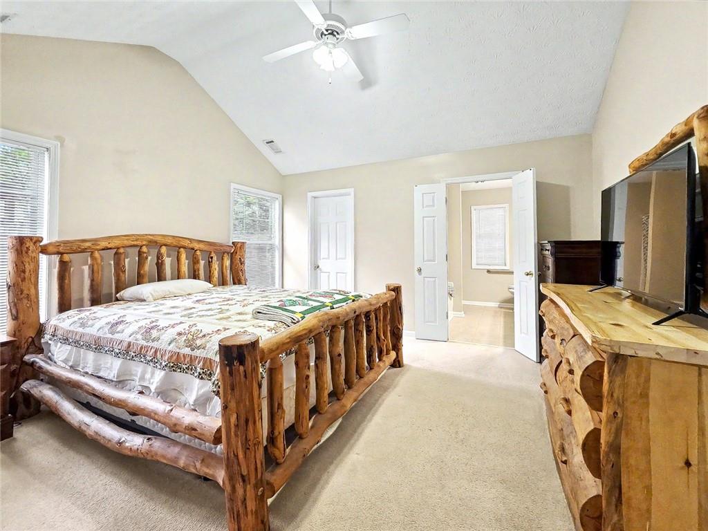 209 Diamond Valley Pass Canton, GA 30114 - Photo 17 of 27 a bedroom with a bed and a flat tv screen on dresser