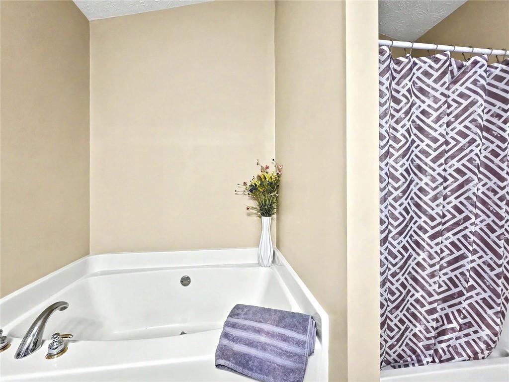 209 Diamond Valley Pass Canton, GA 30114 - Photo 19 of 27 a bathroom with a bathtub and a shower