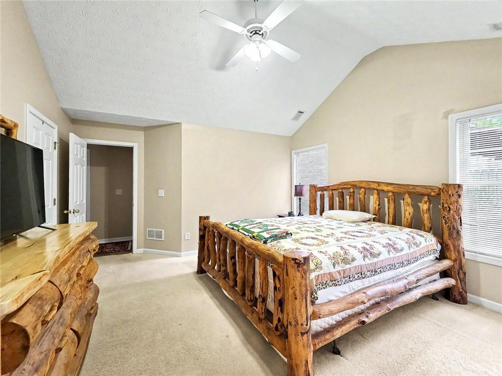 209 Diamond Valley Pass Canton, GA 30114 - Photo 20 of 27 a bedroom with a bed and a chandelier
