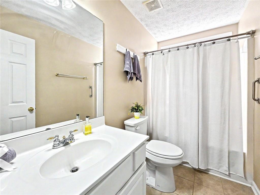 209 Diamond Valley Pass Canton, GA 30114 - Photo 22 of 27 a bathroom with a sink a toilet and shower curtain