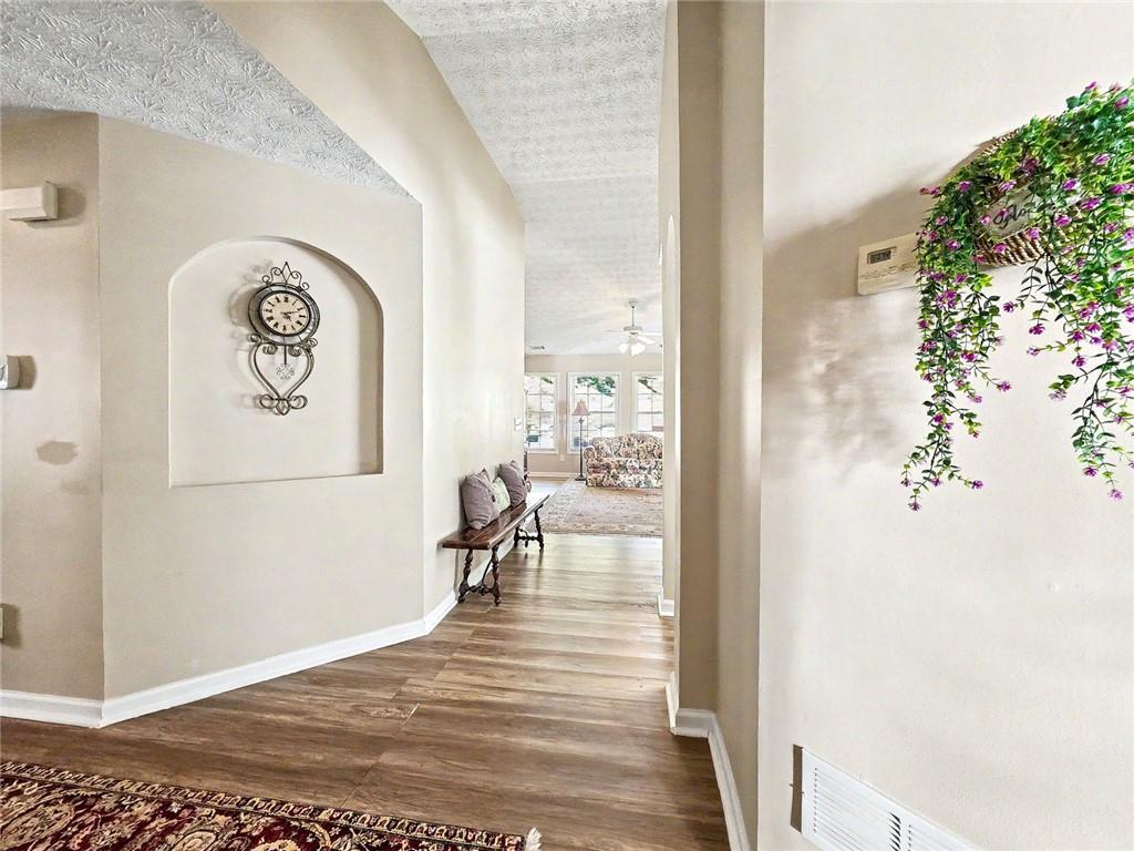 209 Diamond Valley Pass Canton, GA 30114 - Photo 4 of 27 a view of a hallway with wooden floor and a dining table
