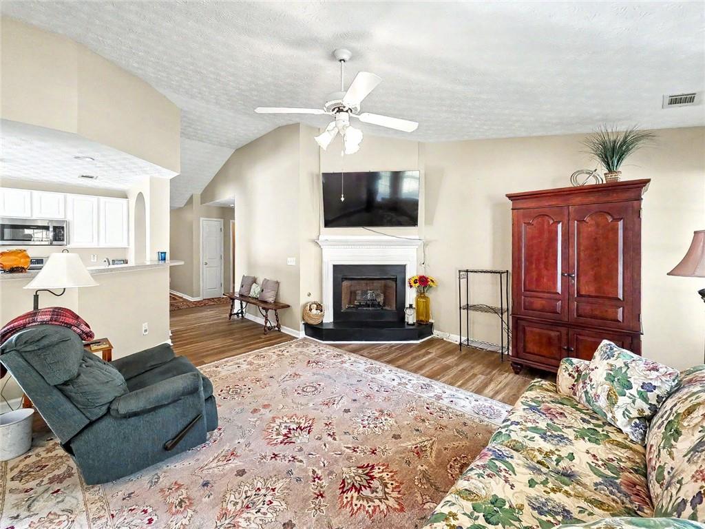 209 Diamond Valley Pass Canton, GA 30114 - Photo 6 of 27 a living room with furniture a flat screen tv and a fireplace