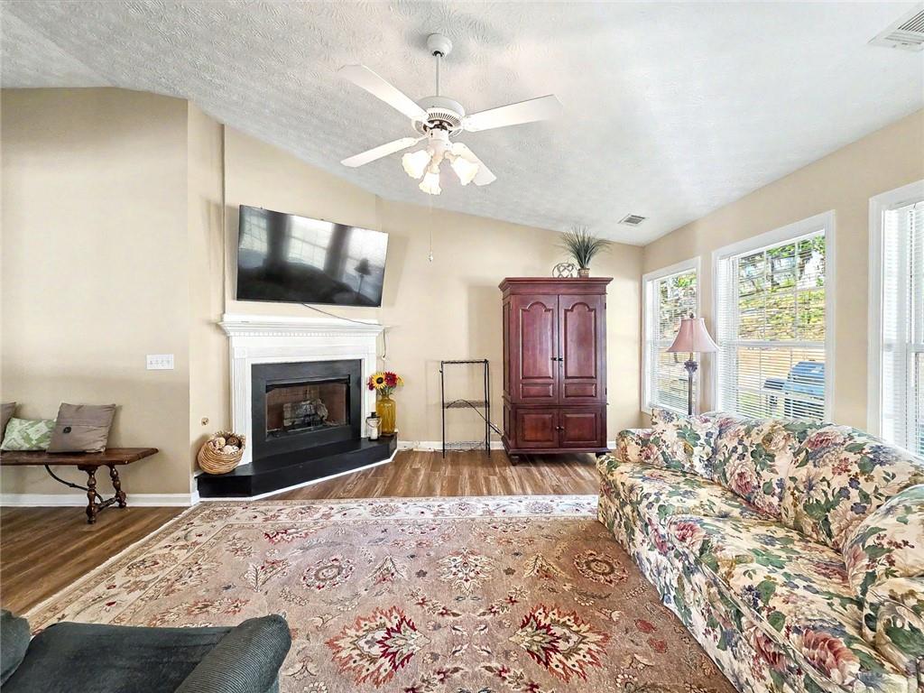 209 Diamond Valley Pass Canton, GA 30114 - Photo 9 of 27 a living room with a fireplace furniture and a flat screen tv
