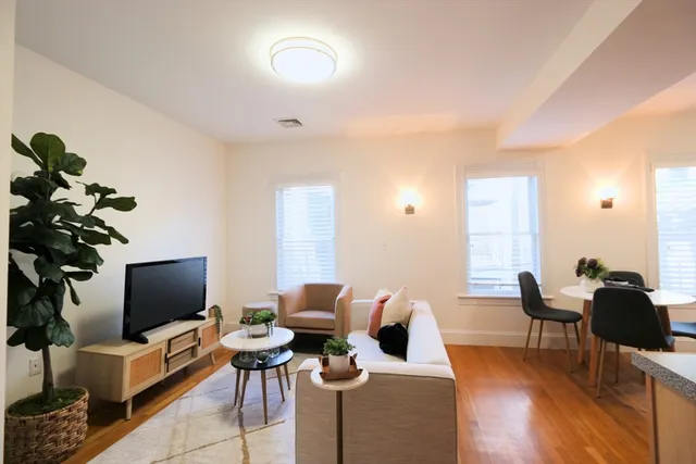 a living room with furniture wooden floor and a flat screen tv