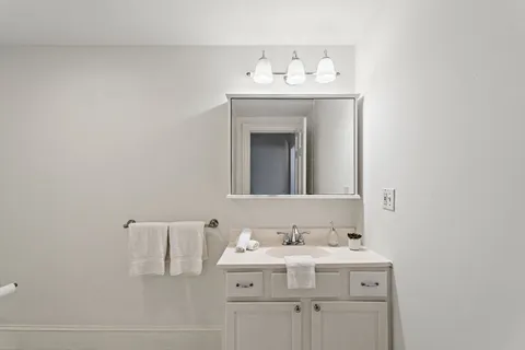 a bathroom with a sink vanity and mirror