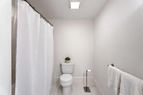 a white toilet sitting next to a shower