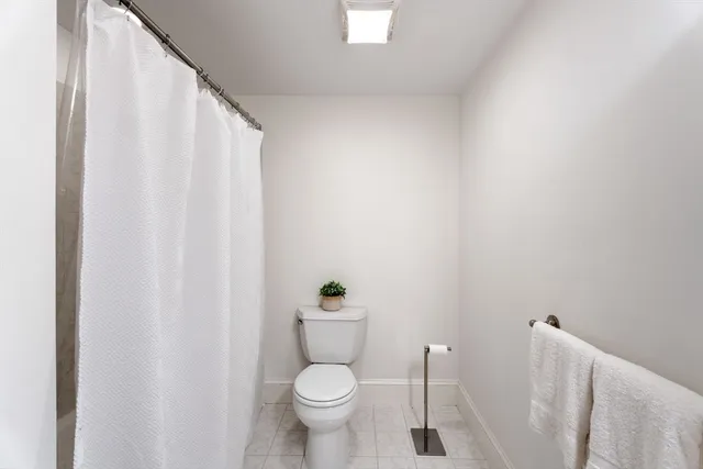 a white toilet sitting next to a shower