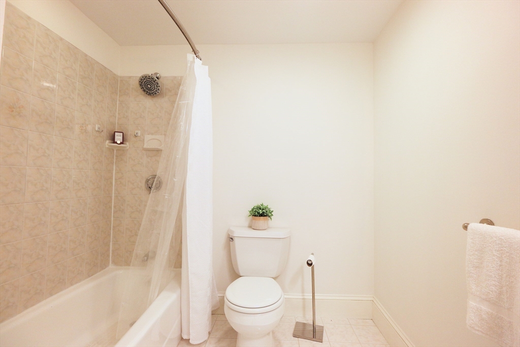 296 West 3rd Street, Unit U1 Boston, MA 02127 - Photo 13 of 22 a white toilet sitting next to a bath tub and a shower