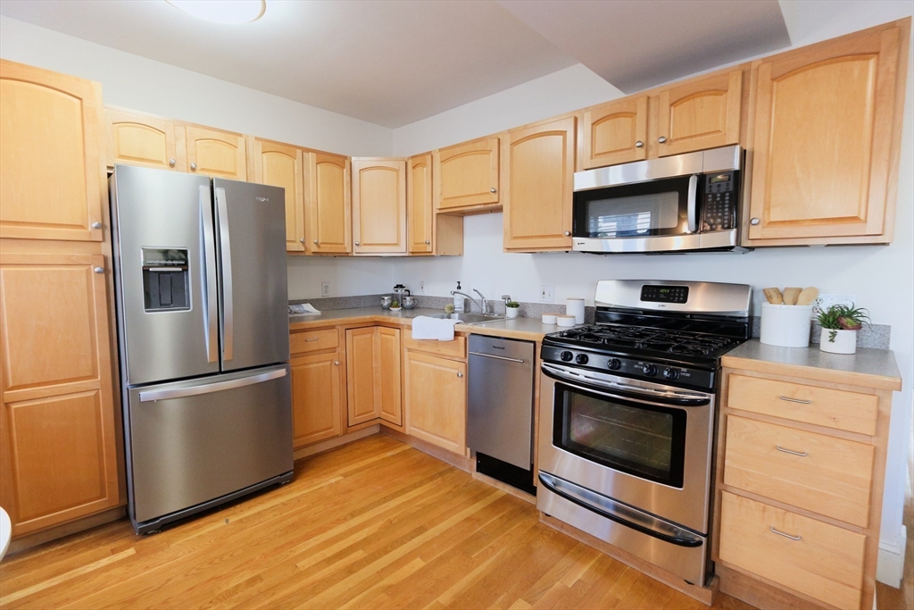 296 West 3rd Street, Unit U1 Boston, MA 02127 - Photo 5 of 22 a kitchen with stainless steel appliances granite countertop a refrigerator stove a sink and a microwave