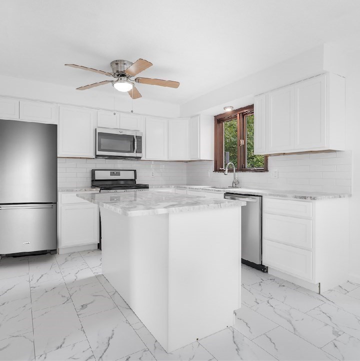 90 Merlin Drive Swansea, MA 02777 - Photo 2 of 13 a kitchen with kitchen island a sink appliances and cabinets