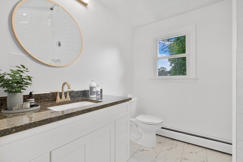 90 Merlin Drive Swansea, MA 02777 - Photo 8 of 13 a bathroom with a granite countertop sink a toilet and mirror