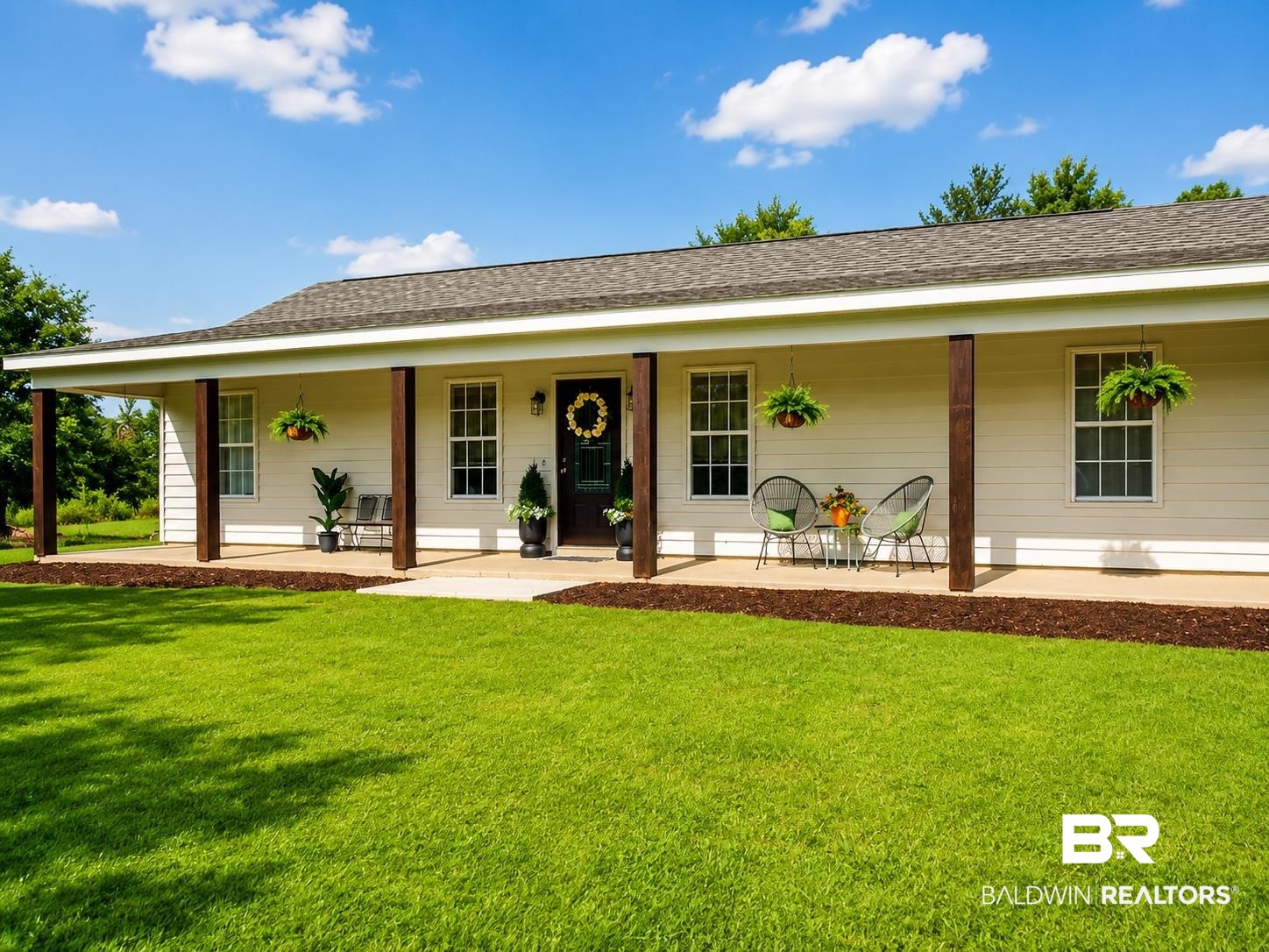 21733 Sedlack Road Silverhill, AL 36576 - Photo 2 of 22 Ranch-style exterior with a covered front porch, white siding, dark wood-tone support columns, a dark shingle roof, and a concrete walkway