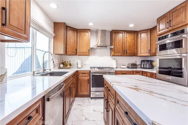 a kitchen with stainless steel appliances kitchen island granite countertop a sink stove and cabinets