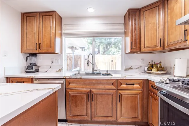 a kitchen with granite countertop cabinets stainless steel appliances and a sink