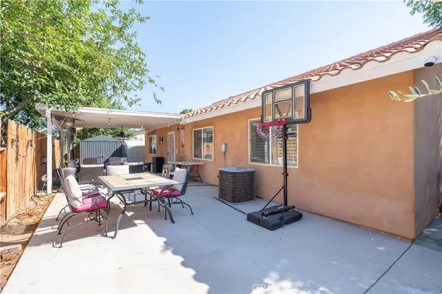 a view of a patio with a table and chairs and floor to ceiling window