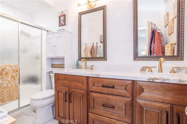 a bathroom with a granite countertop sink mirror vanity and toilet