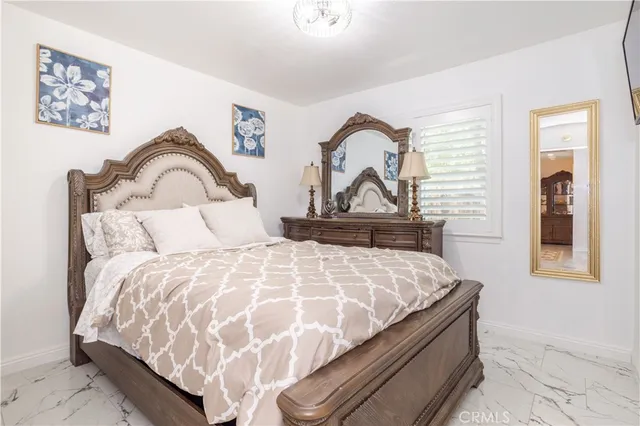 a bedroom with a bed and a potted plant on the dresser