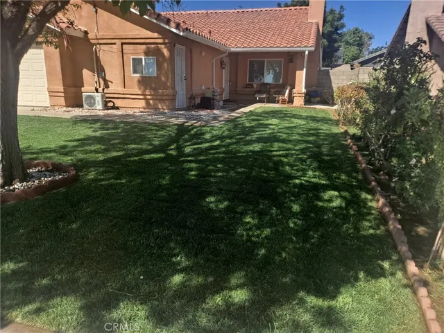 a view of a house with backyard and sitting area