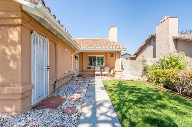 a view of a house with backyard and sitting area