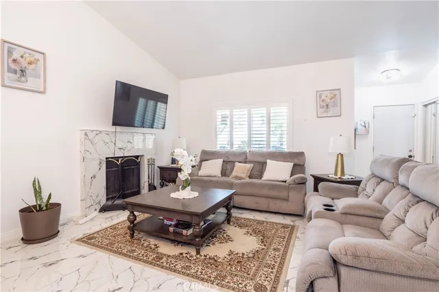 a living room with furniture a fireplace and a flat screen tv
