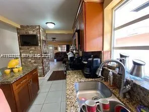 a kitchen with sink a faucet and chairs