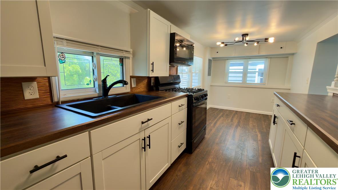 246 Poplar Street Bath, PA 18014 - Photo 22 of 34 A contemporary kitchen showcasing rich wood-tone counters and sleek cabinetry with modern lighting.