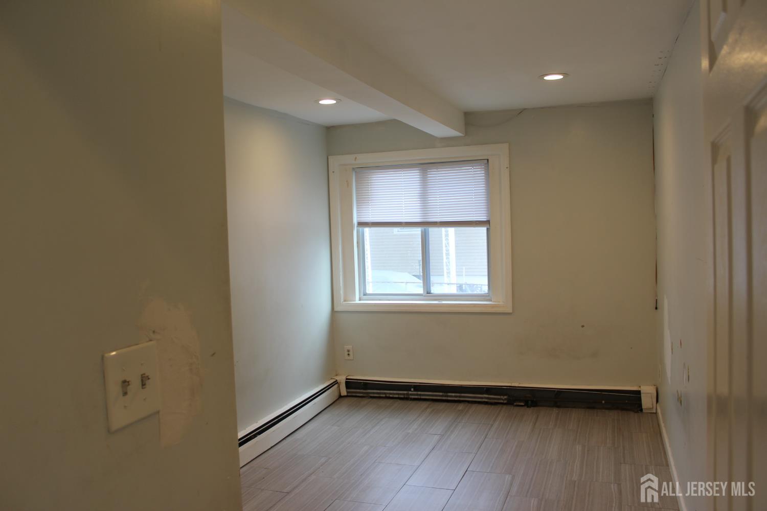 899 Green Street, Unit 1 Iselin, NJ 08830 - Photo 21 of 45 a view of an empty room with wooden floor and a window