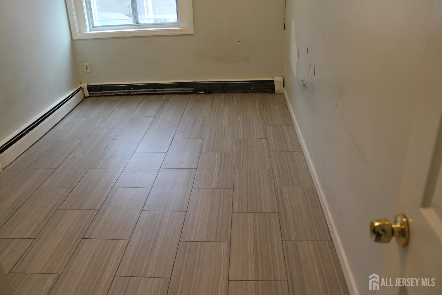 899 Green Street, Unit 1 Iselin, NJ 08830 - Photo 22 of 45 an empty room with wooden floor and a window