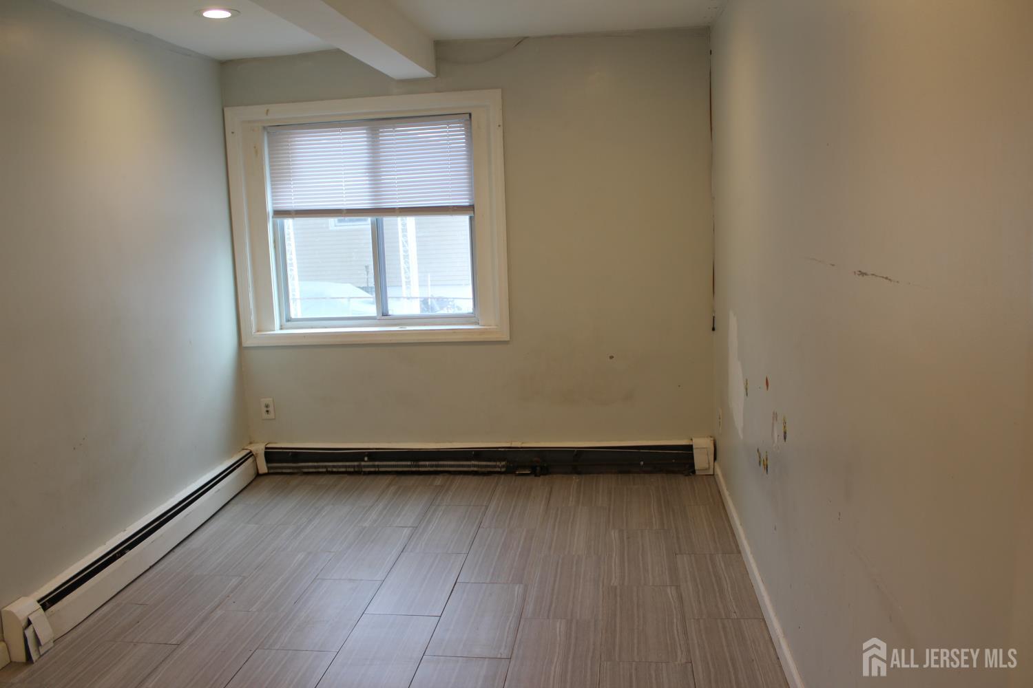 899 Green Street, Unit 1 Iselin, NJ 08830 - Photo 23 of 45 an empty room with wooden floor and windows