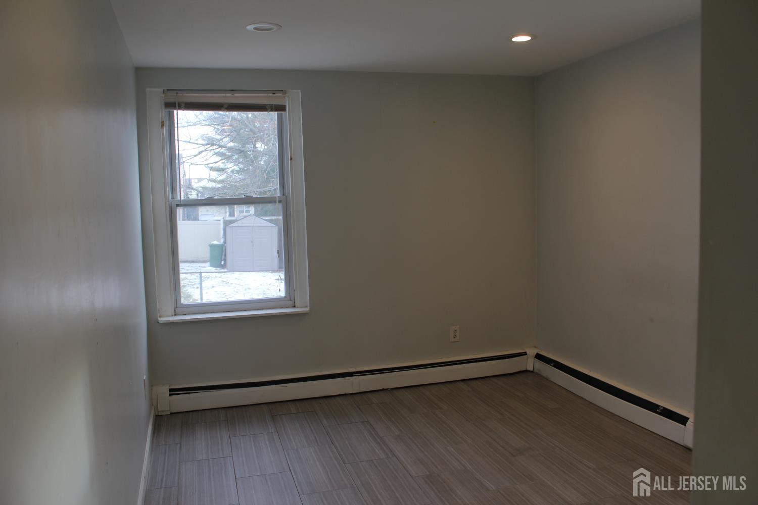 899 Green Street, Unit 1 Iselin, NJ 08830 - Photo 28 of 45 an empty room with wooden floor and windows