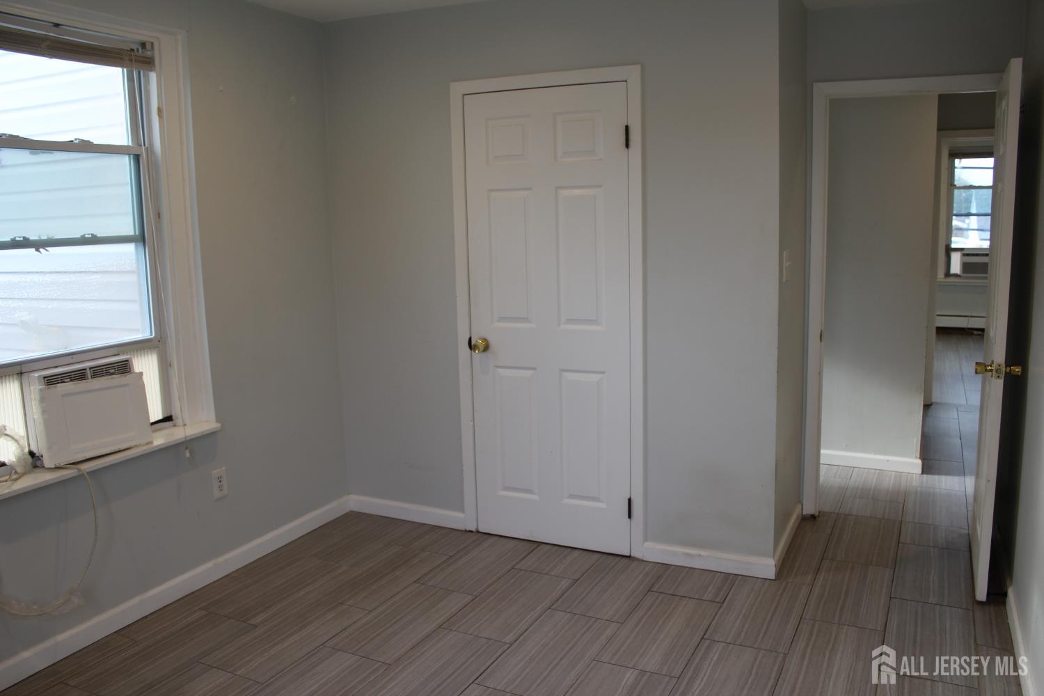 899 Green Street, Unit 1 Iselin, NJ 08830 - Photo 29 of 45 an empty room with wooden floor cabinet and windows