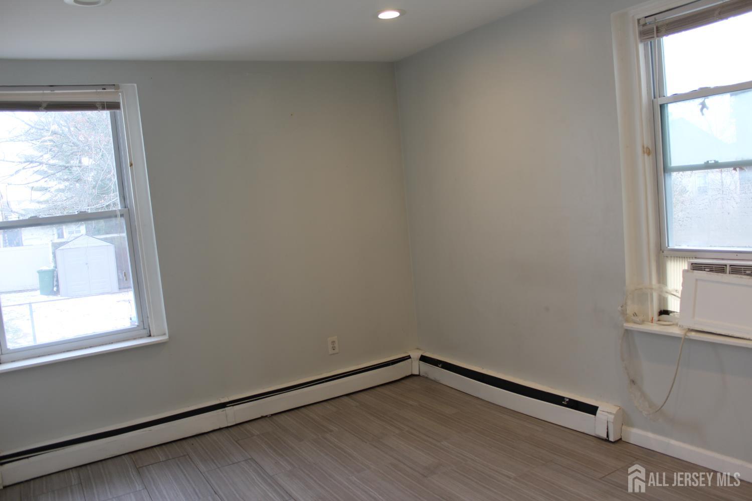 899 Green Street, Unit 1 Iselin, NJ 08830 - Photo 31 of 45 a view of an empty room with wooden floor and a window