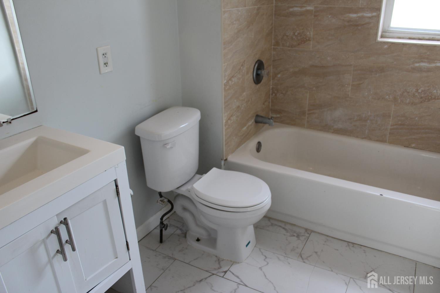 899 Green Street, Unit 1 Iselin, NJ 08830 - Photo 32 of 45 a white toilet sitting next to a bath tub