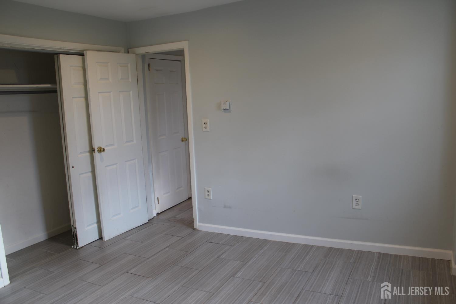 899 Green Street, Unit 1 Iselin, NJ 08830 - Photo 38 of 45 an empty room with wooden floor and closet
