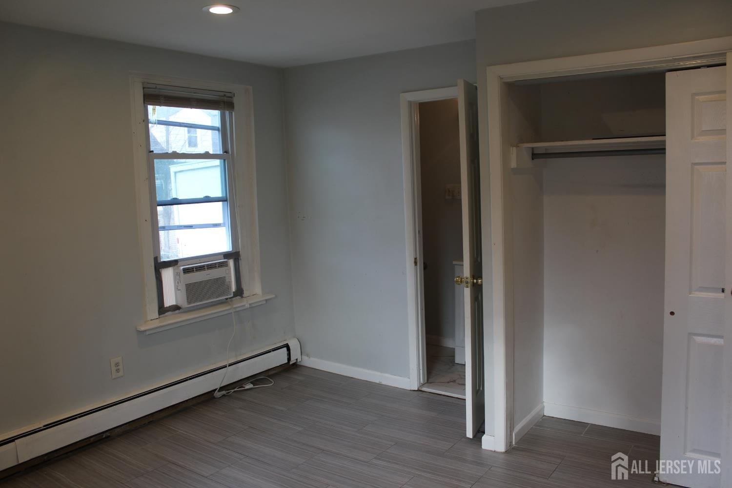 899 Green Street, Unit 1 Iselin, NJ 08830 - Photo 39 of 45 an empty room with wooden floor closet and windows