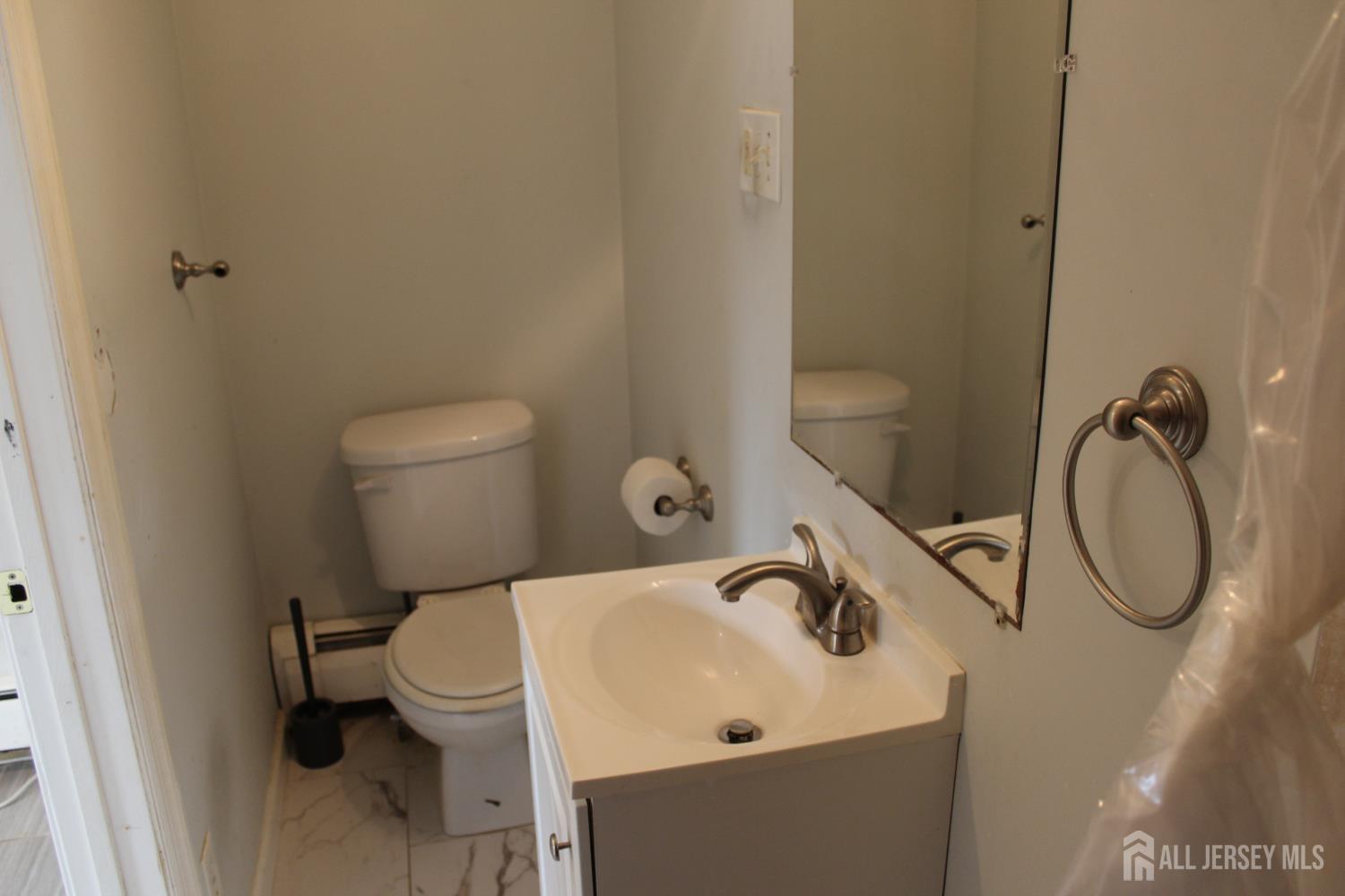 899 Green Street, Unit 1 Iselin, NJ 08830 - Photo 41 of 45 a bathroom with a sink a toilet and a a mirror