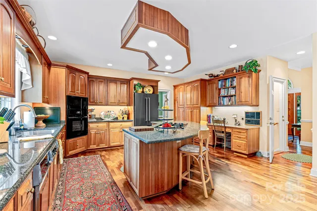 a kitchen with granite countertop a stove a sink and a refrigerator