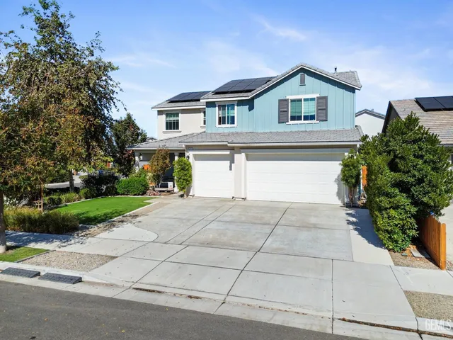 a front view of a house with a yard and a garage