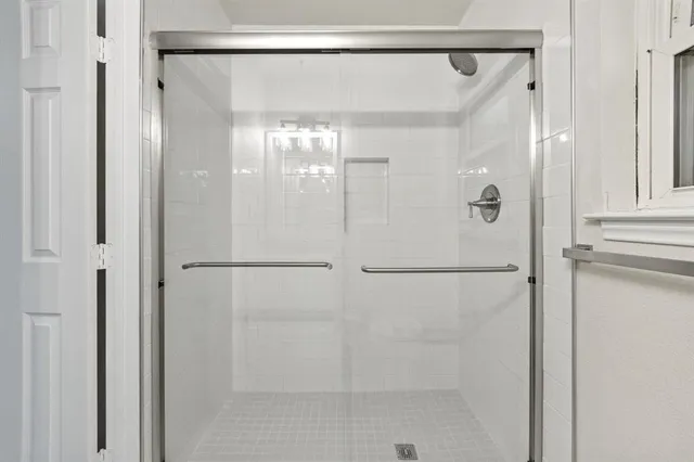 a bathroom with a glass shower door and a shower