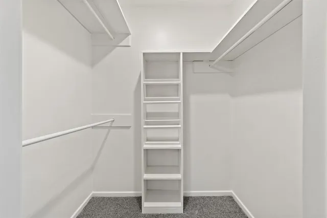 a view of walk in closet with empty racks