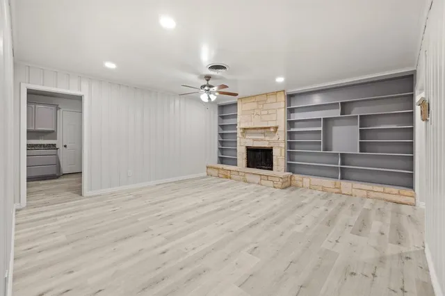 a view of an empty room with a fireplace and a window