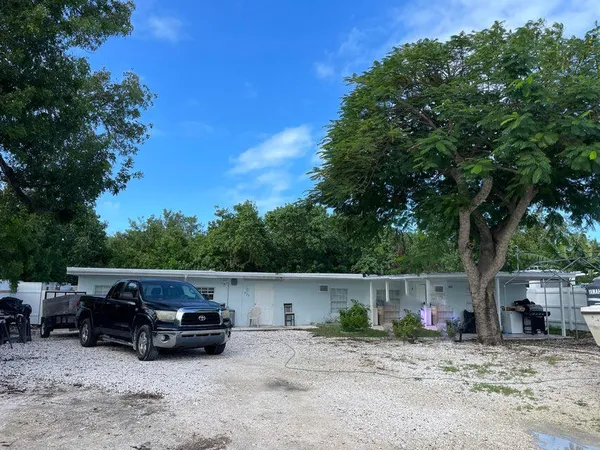 a view of backyard with parked cars