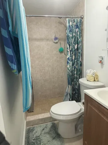 a white toilet sitting next to a bathroom sink and vanity
