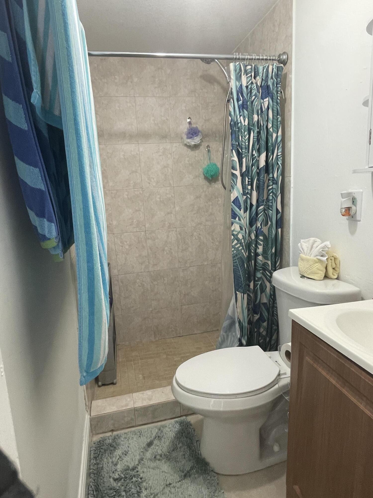 625 73rd Street, Unit AB Marathon, FL 33050 - Photo 18 of 23 a white toilet sitting next to a bathroom sink and vanity