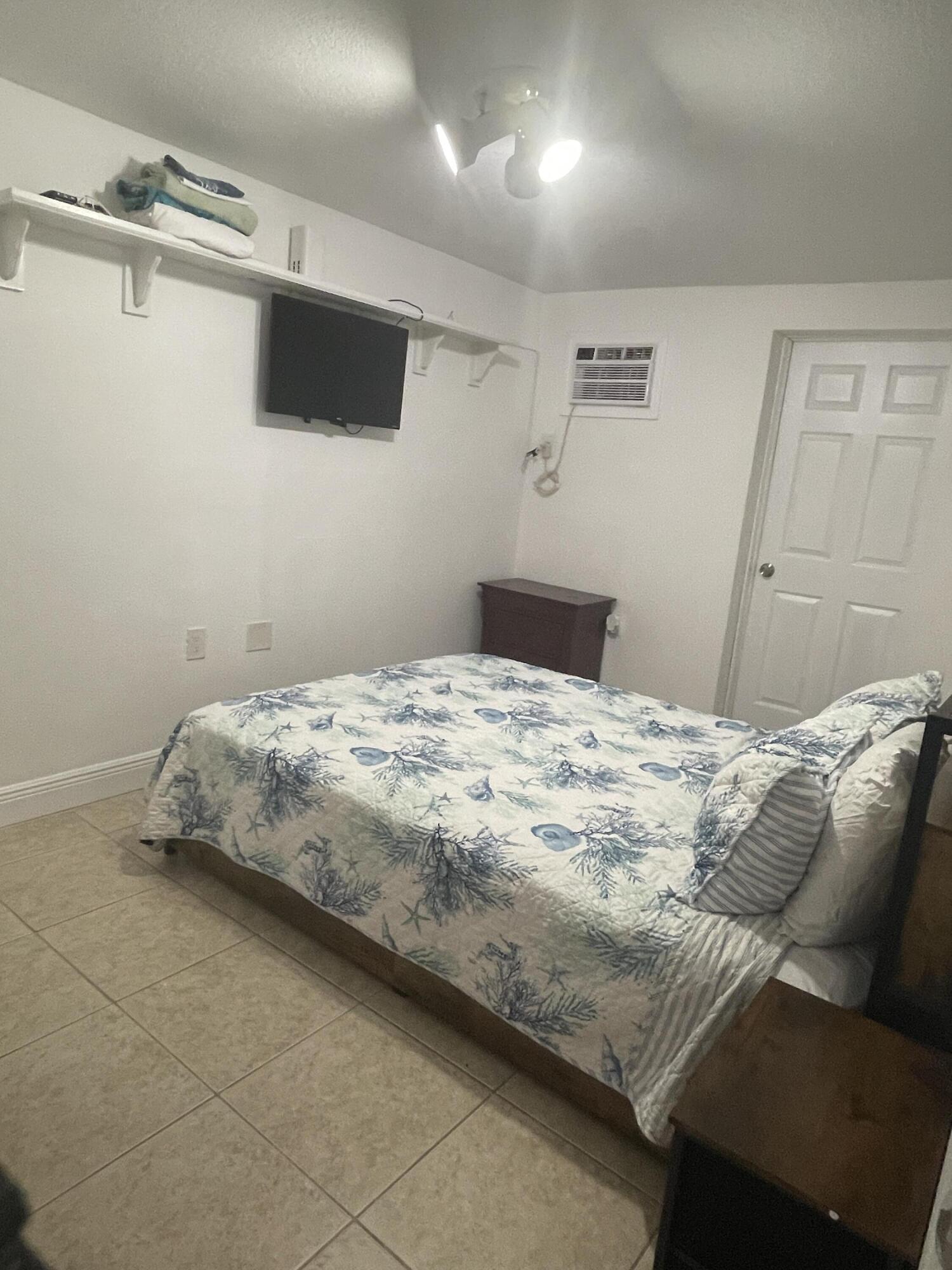 625 73rd Street, Unit AB Marathon, FL 33050 - Photo 19 of 23 a bedroom with a bed and a flat screen tv